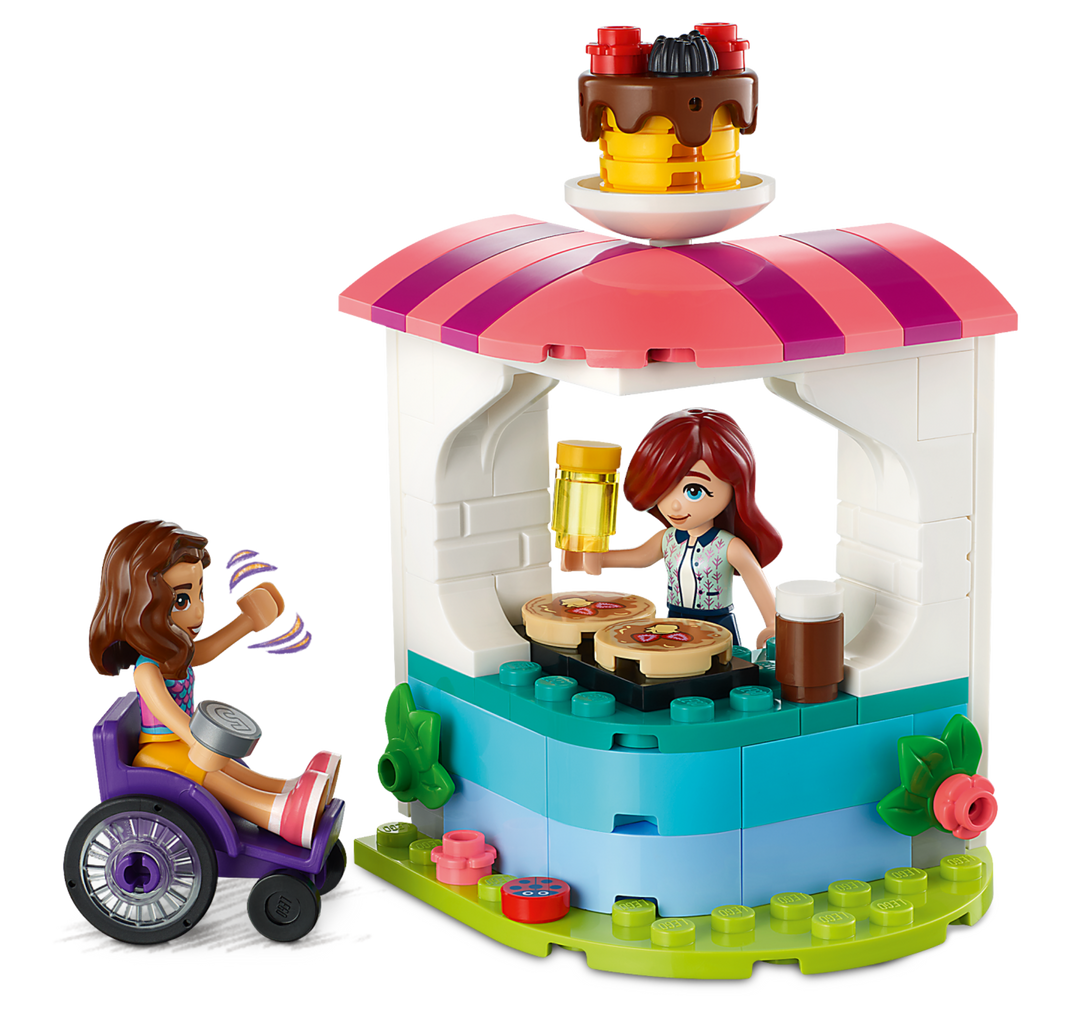 Close-up of the pancake kiosk with Luna serving and Paisley in her wheelchair