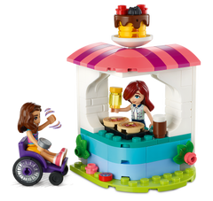 Close-up of the pancake kiosk with Luna serving and Paisley in her wheelchair