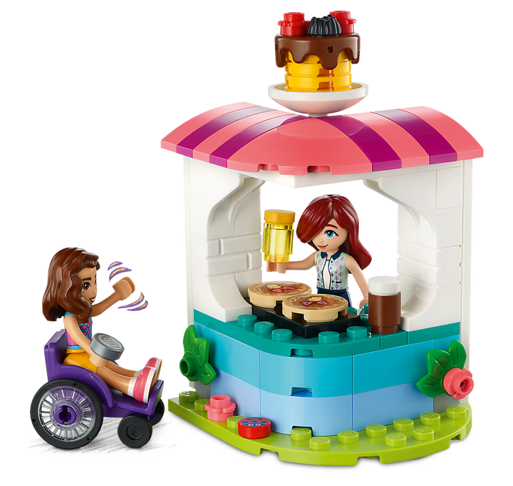 Close-up of the pancake kiosk with Luna serving and Paisley in her wheelchair