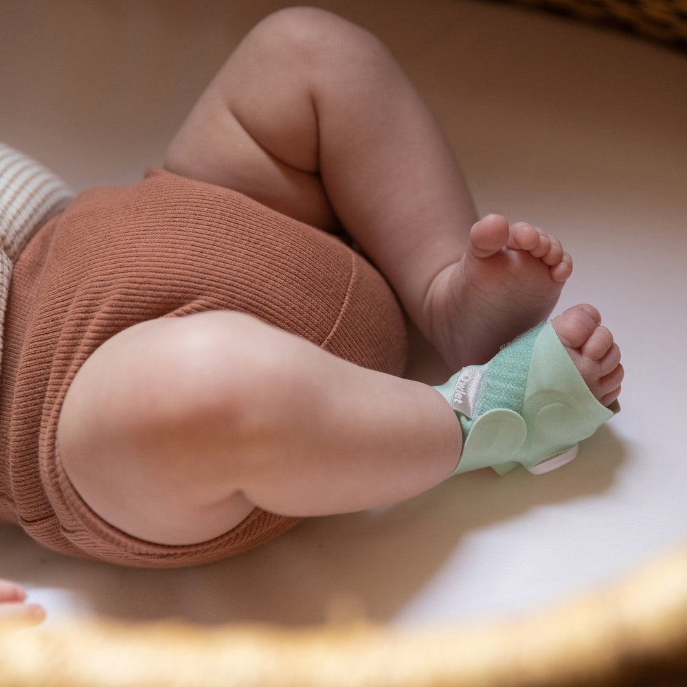 Owlet Smart Sock 3 mint fabric sock on an infant foot, official photography