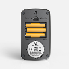 Back of the Airthings Corentium Home with the cover off, showing 3 AAA batteries, the Reset and Mode buttons and the wall hanging slot