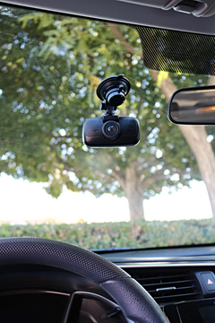 myGEKOgear Orbit 960 dash cam on its suction cup mount behind a car windshield