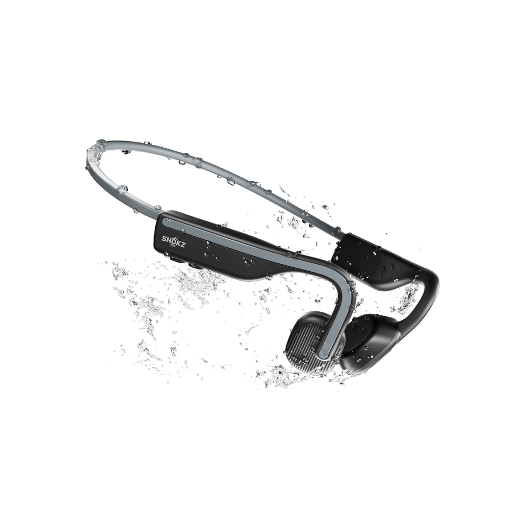 Shokz OpenMove in Slate Grey splashed with water, showing the IP55 sweat and water resistance