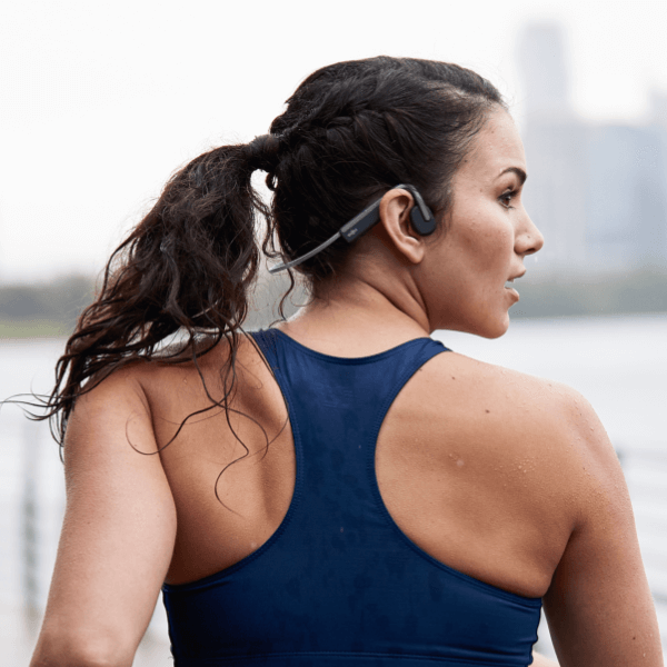 Runner wearing the Shokz OpenMove in Slate Grey, open ear with the band behind the head