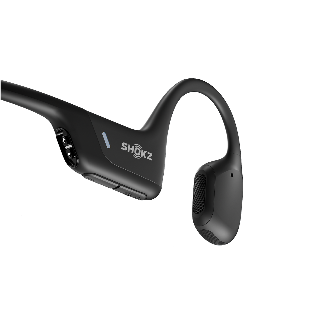 Close-up of the Shokz OpenRun Pro black battery housing with the magnetic charging port, LED and volume buttons