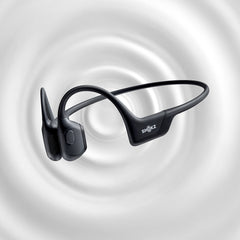 Shokz OpenRun Pro in black over a grey ripple background suggesting sound waves