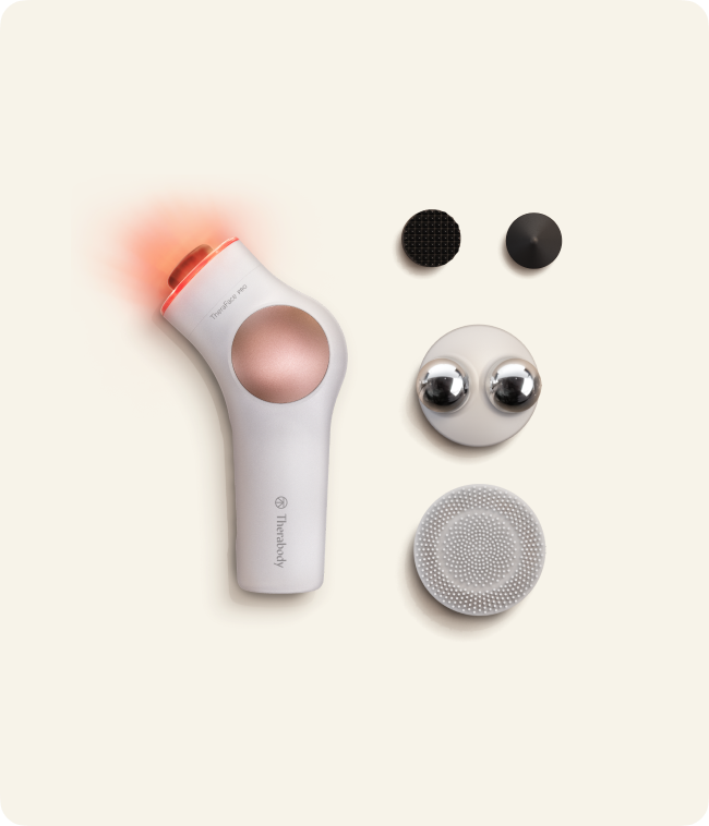 TheraFace PRO white beside its percussive attachments, Microcurrent Ring and Cleansing Ring