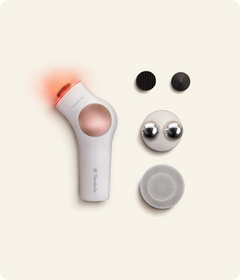 TheraFace PRO white beside its percussive attachments, Microcurrent Ring and Cleansing Ring